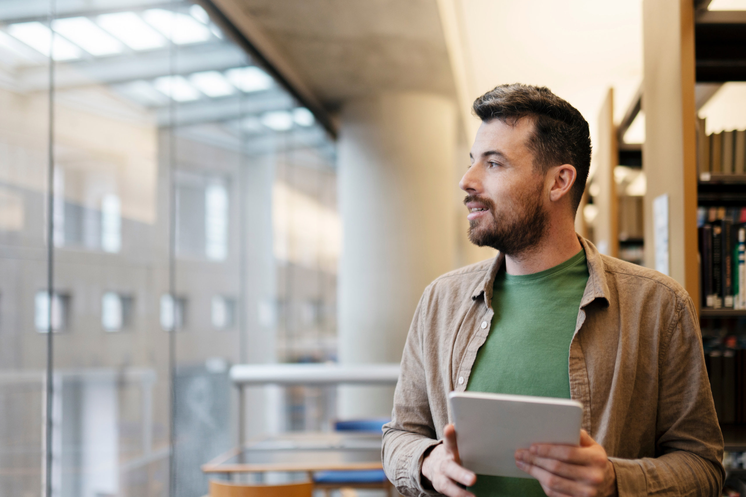 En ung man tittar ut genom ett fönster och funderar över sin framtid.