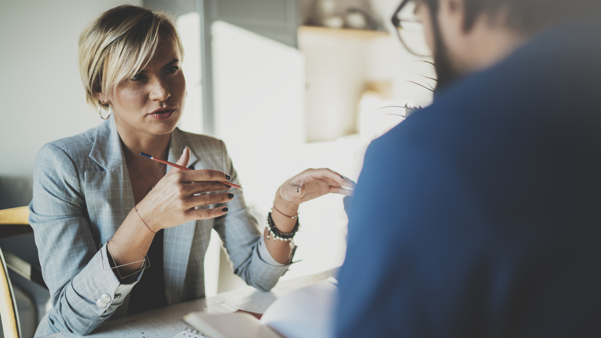 Samtal mellan kvinna och man i ett mötesrum.