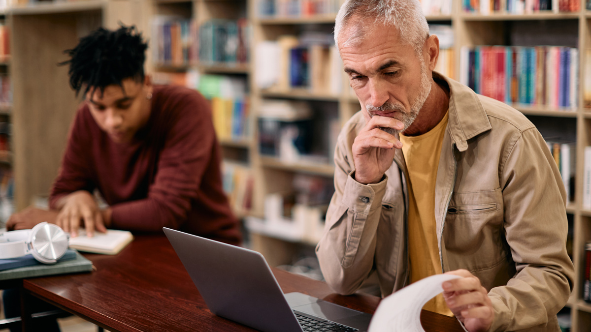 En man sitter vid datorn och funderar.