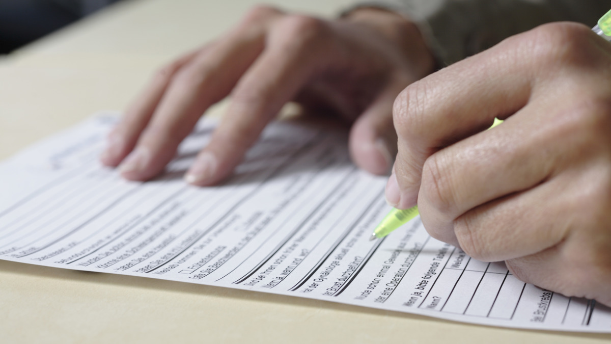 Händer som fyller i formulär.